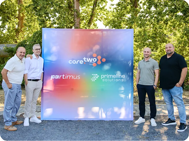 Die Geschäftsführer der core.two Unternehmensgruppe neben einem Banner mit den drei Logos der Gruppe